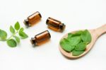 Mint Essential Oil In A Glass Bottle With Leaves On White Backgr Stock Photo