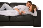 Teenage Couple Lying On Sofa Stock Photo