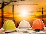 Safety Helmet On Engineer Working Table And Construction Site Stock Photo