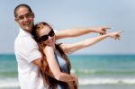 Couple Pointing At The Sea Stock Photo