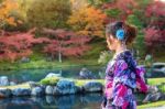 Asian Woman Wearing Japanese Traditional Kimono In Autumn Park. Japan Stock Photo