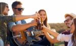 Portrait Of Group Of Friends Toasting With Bottles Of Beer Stock Photo