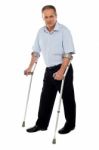 Senior Man Standing With Crutches Stock Photo