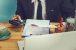 Business Man Sitting On A Calculator To Figure Out In A Coffee S Stock Photo