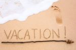 Inscription Of Vacation Written On Wet Yellow Beach Sand With Fo Stock Photo