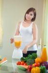 Young Woman Making Fruit Smoothie In Blender Stock Photo