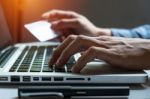 Man Holding Credit Card In Hand And Entering Security Code Using Stock Photo