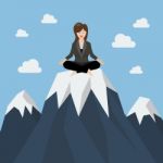 Business Woman Meditating On A Mountain Peak Stock Photo