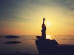 Silhouette Yoga Girl By The Beach At Sunrise Stock Photo