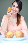 Happy Young Woman Eating Delicious Muffins Stock Photo