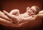 Parents Holding Baby Girl On Their Arms Stock Photo