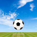 Soccer Ball With Soccer Field Against  Blue Sky Background Stock Photo