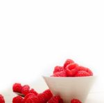 Bunch Of Fresh Raspberry On A Bowl And White Table Stock Photo