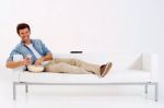 Man On Sofa Watching TV With Remote Stock Photo