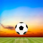 Soccer Ball With Soccer Field Against Beautiful Sunset Stock Photo