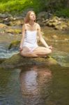 Woman Doing Yoga On Rock Stock Photo