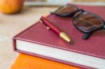 Pen And Glasses On Books Stock Photo