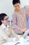 Two Young Businesswomen Working With Digital Tablet In Her Offic Stock Photo