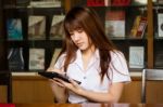 Portrait Of Thai Adult Student University Uniform Beautiful Girl Using Her Tablet Stock Photo