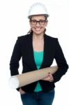 Confident Female Architect Carrying Blueprints Stock Photo