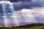 Sunlight Beams Over Clouds In Mountains. Rays In Cloudy Sky Stock Photo