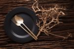 Black Empty Plate Fork Spoon On Wooden Table Background Stock Photo