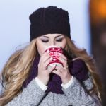 Attractive Young Stylish Blonde Girl Drinks Hot Drink From A Mug Stock Photo