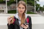 Teenager Eating Cake Looking In Phone Stock Photo