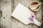 Wooden Chopping Board On Old Wooden Table. Top View Stock Photo