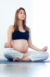 Pregnant Woman Relax Doing Yoga, Sitting In Lotus Position Stock Photo