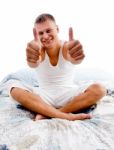 Sitting Young Man Showing Thumb Up Stock Photo