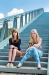 Two Dutch Girls Sitting On Metal Bridge Stock Photo