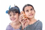 Two Little Girls Holding A Sea Shell Isolated On White Stock Photo