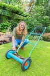 Young Dutch Woman Reparing Lawn Mower In Garden Stock Photo