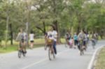 Blurred Image Of People Riding Bicycle In Park Stock Photo