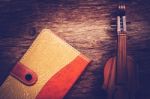 Violin And Notebook On Grunge Dark Wood Background, Vintage Style Stock Photo