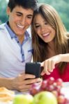 Couple Using Smart Phone On Romantic Picinic Stock Photo