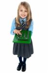 Pretty Child In School Uniform Using Calculator Stock Photo