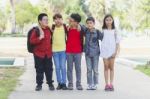 Group Of Kids Friends Arm Around Standing Having Fun And Smiling In Park Stock Photo