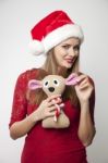 Woman In Santa Hat Holding Reindeer Toy Stock Photo