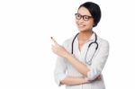 Female Physician Pointing And Looking Away Stock Photo