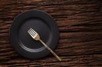 Black Empty Plate Fork On Wooden Table Background Stock Photo