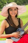 Asian Woman Playing Ukulele Stock Photo