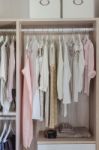 Clothes Hanging In Wooden Wardrobe Stock Photo