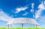 Solar Panels On Green Grass Field Against Blue Sky Background Stock Photo