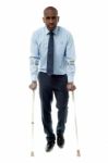 Middle Aged Man Walking With Two Crutches Stock Photo