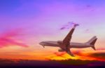 Commercial Airplane Flying At Sunset Stock Photo