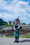 Bagpipe Player At Famous Eilean Donan Castle In Scotland Stock Photo