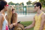 Group Of Friends With Roller Skates And Bike Riding In The Park Stock Photo