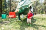 The Boy Is Walking Around Dinosaur Statue Stock Photo